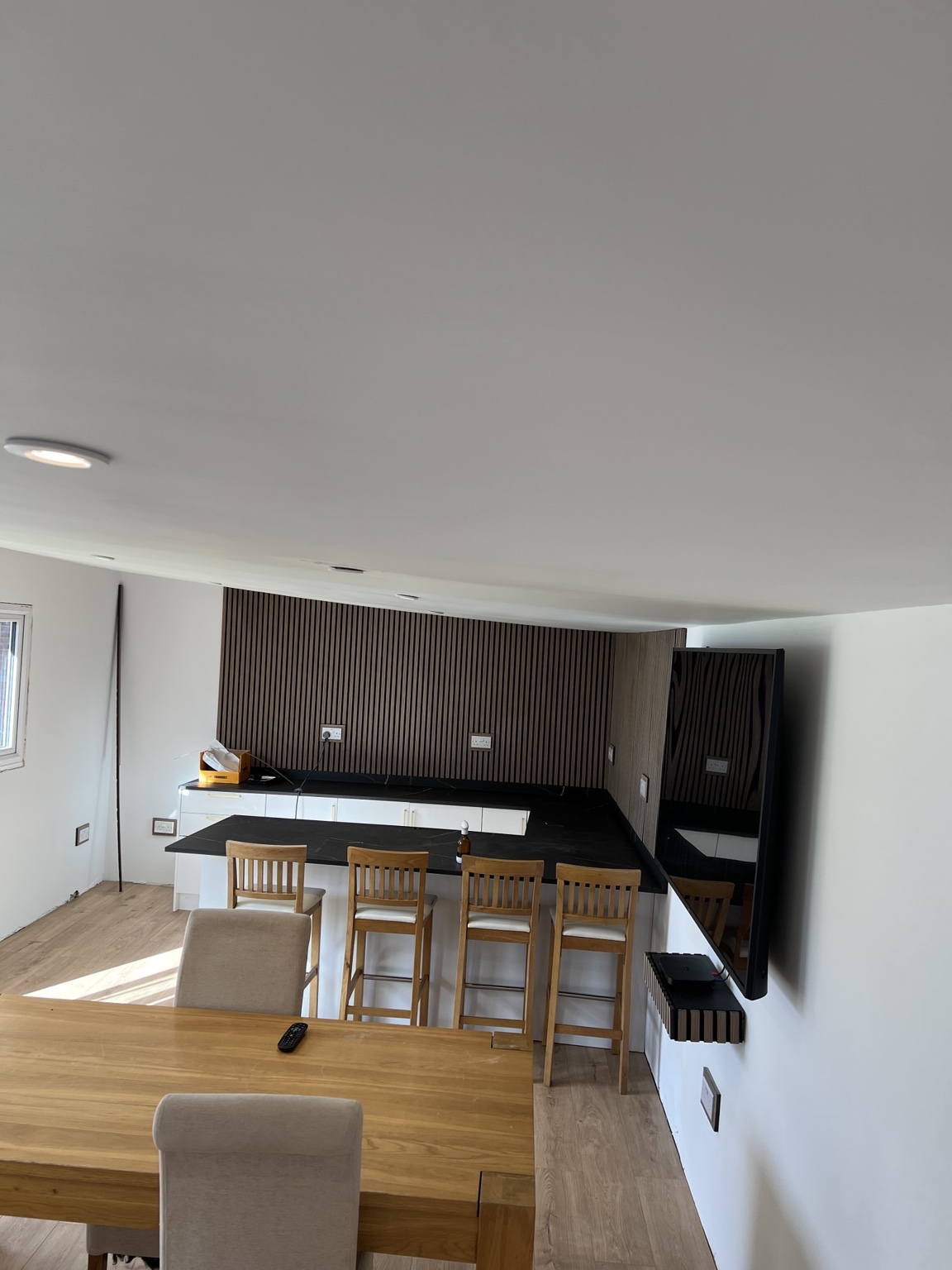 Completed garden room interior with bespoke bar, television and feature wall
