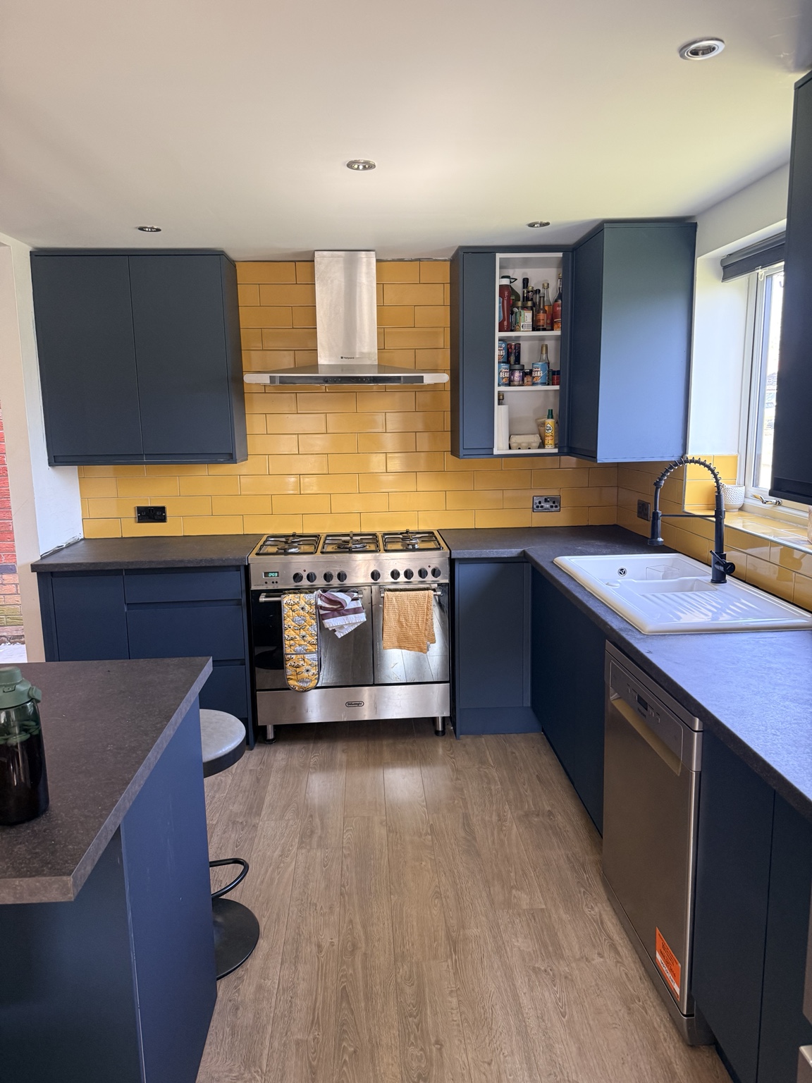 Finished blue kitchen renovation with tiled splashback
