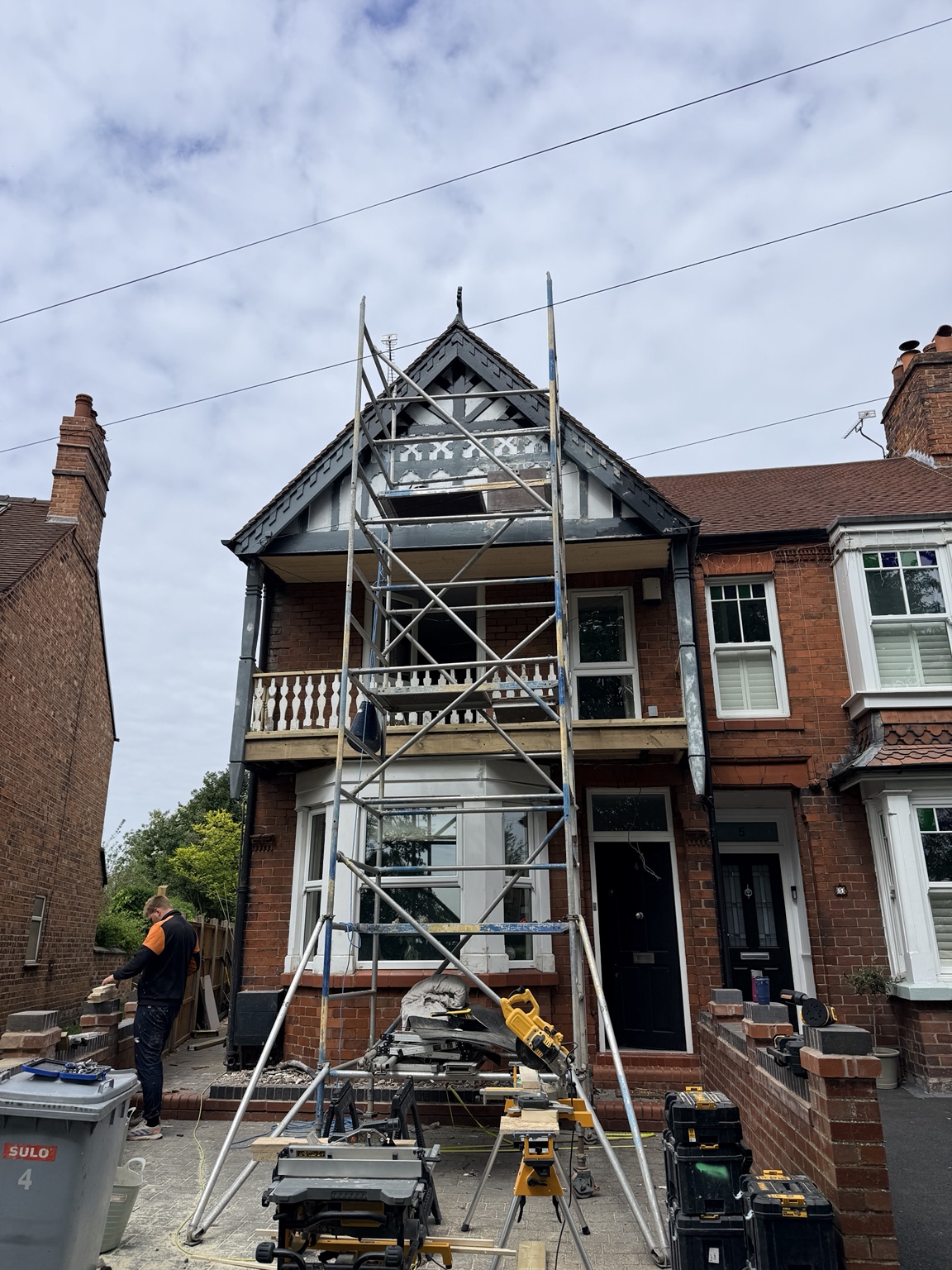 Scaffolding and structural work during a Tudor-style frontage renovation